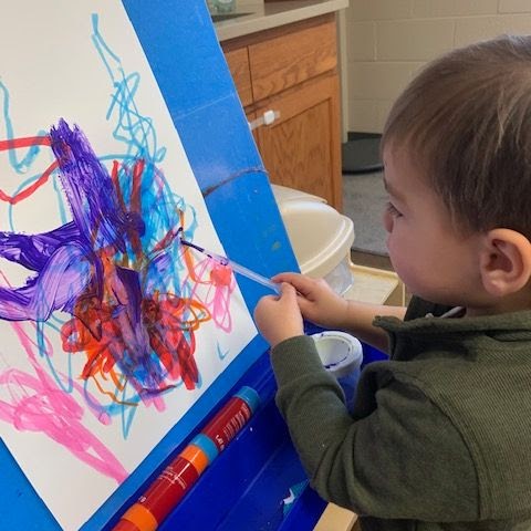 Preschool boy painting a picture